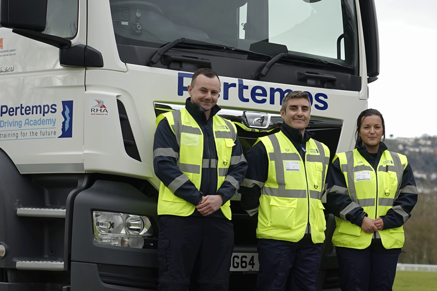 people in high vis stood in front of a lorry